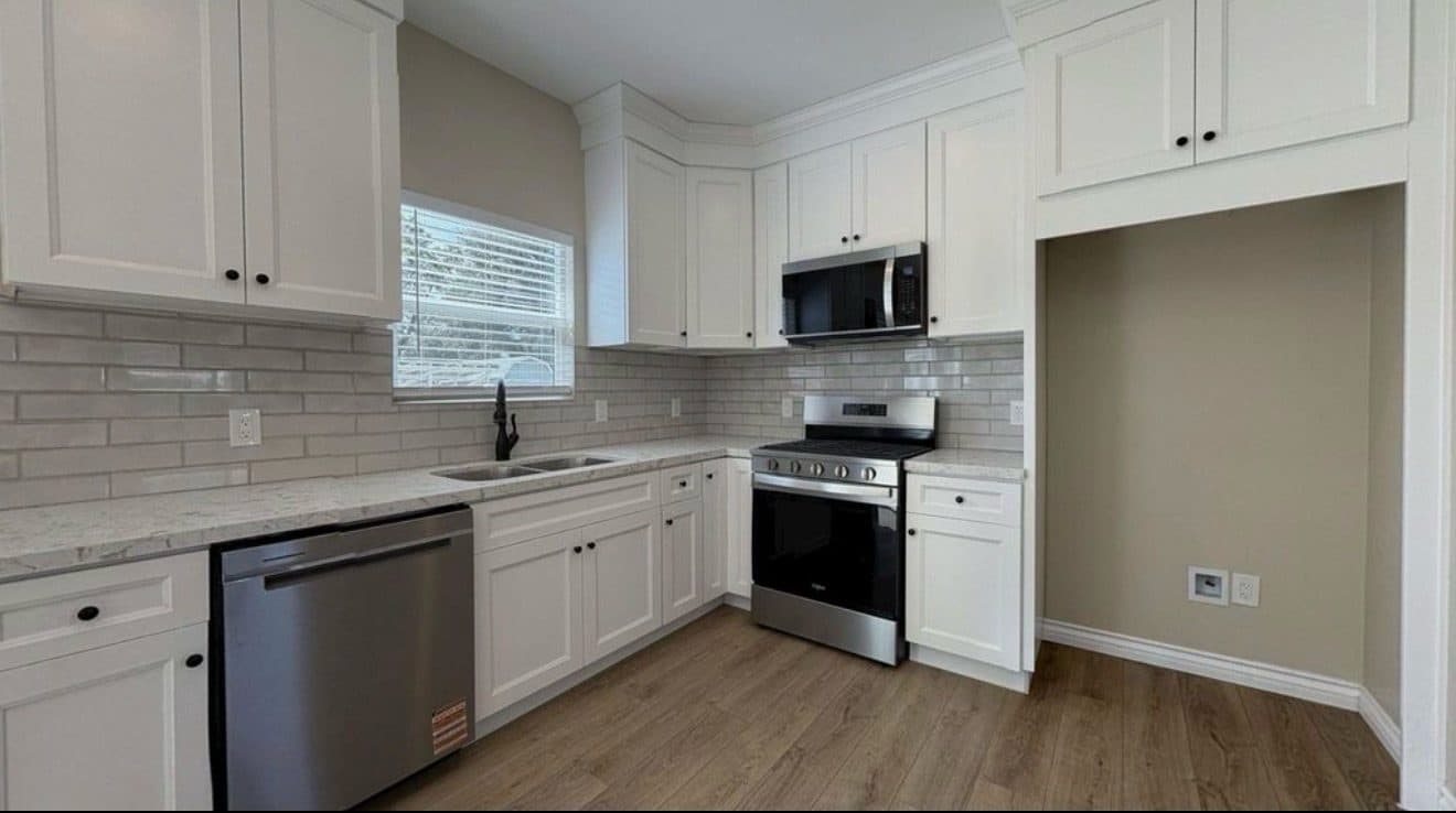 MJ Remodel job photo from an ADU completed in Redlands, CA: white shaker kitchen with a black faucet and stainless appliances
